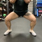 Someone squatting with a wide stance