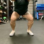 Someone squatting with left foot turned out